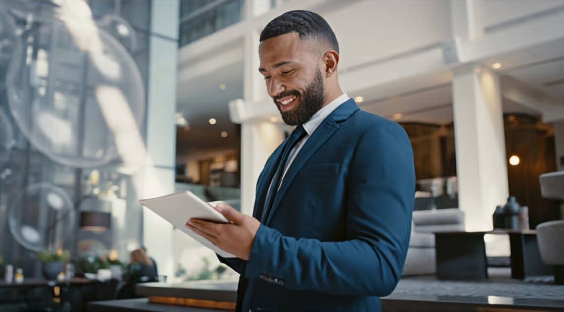 Suited man looking at tablet device.